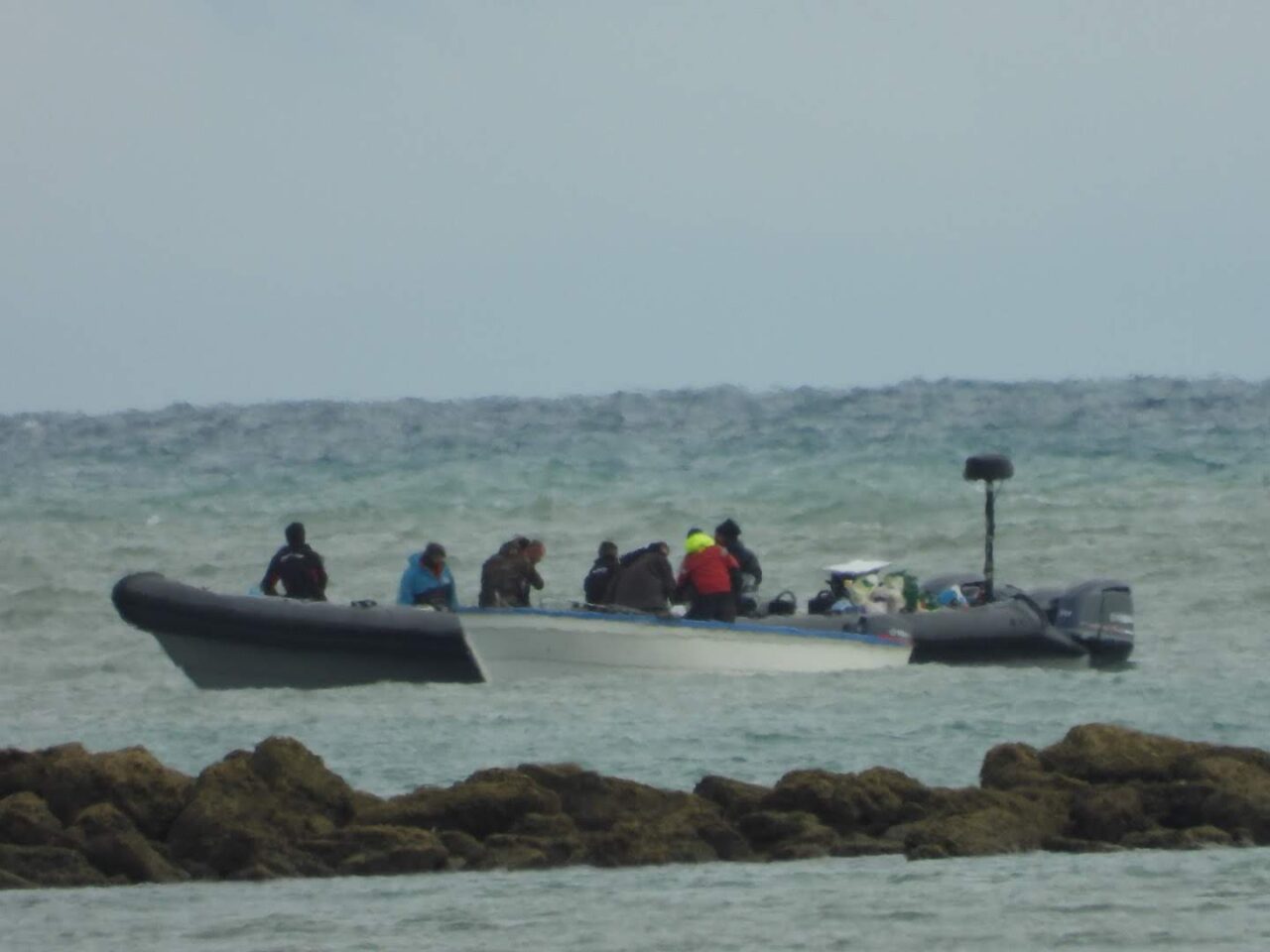 Embarcación semirrígida en la costa con varias personas a bordo manipulando bidones junto a otra lancha, asociada al suministro de combustible para narcolanchas.
